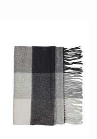 Woven blanket in gray, black, and white plaid pattern with fringed edges. Textured fabric with varied color blocks and geometric design.