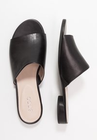 Černé kožené nazouvací sandály s širokým svrškem, otevřenou špičkou, nízkým podpatkem a hladkým povrchem. Diskrétní logo na stélce.