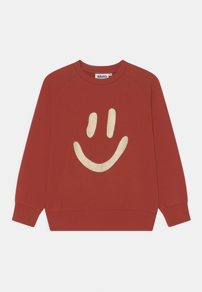 Sweatshirt rouge avec un col rond et des manches raglan. Présente un grand design d'un visage souriant doré sur le devant. Fabriqué en coton doux.