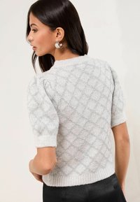 Svetlo šedý pletený sveter s diamantovým vzorom, krátkymi puff rukávmi, rebrovaným výstrihom a striebornými vláknami pre zvýraznenie textúry.