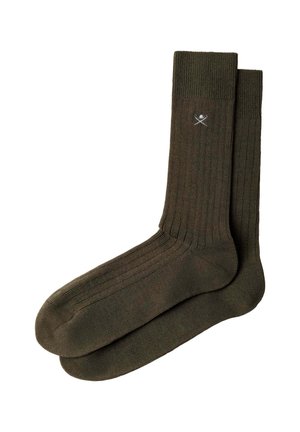 Par de calcetines verdes oscuros acanalados hasta el tobillo con un pequeño logo blanco de espadas cruzadas y casco cerca del puño superior.
