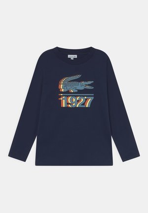 Granatowa koszula z długim rękawem z wielokolorową grafiką krokodyla i napisem ""1927"" z przodu.
