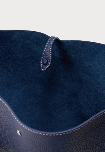 Εσωτερικό τσάντας από μπλε δέρμα με απαλό καστόρινο ύφασμα. Διαθέτει κλείσιμο με κουμπί από λείο δέρμα και αντίθετη ραφή κατά μήκος της άκρης.