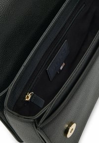 Borsa a mano in pelle nera con finitura texture, hardware dorato, tasca interna con zip e etichetta con marchio visibile all'interno.