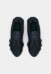 Μαύρα αθλητικά παπούτσια με μοβ λεπτομέρειες, πλέγμα πάνω μέρος, στρογγυλά κορδόνια, υφασμάτινες σόλες καιDistinctive cushioned heel sections.