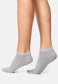 Calzini alla caviglia grigi chiari con polsino a coste, texture liscia, design senza cuciture e leggero elastico, adatti per un abbigliamento casual e per uso interno.