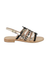 Sandaletti con cinturini caratterizzati da un mix di colori nero, oro e motivo pitonato. Una suola in legno piatta e una fibbia regolabile alla caviglia completano il design.