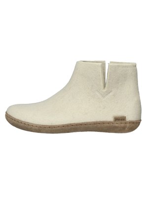 Weicher cremefarbener Kurzstiefel mit strukturierter hellbrauner Sohle und kleinem Zuglasche an der Seite, seitlich dargestellt.