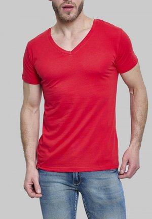 T-shirt rouge à col en V fabriqué en coton léger, design ajusté, manches courtes, texture lisse, porté avec un jean bleu.