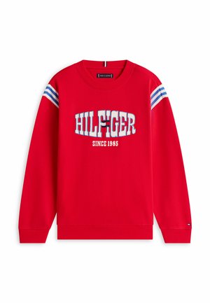 Rød sweatshirt med hvide og blå striber på skuldrene, "HILFIGER" tekst og logo på brystet, og "SINCE 1985" trykt nedenunder.