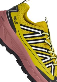 Chaussure de course jaune avec une tige en maille respirante, des rayures noires et blanches audacieuses, une semelle intermédiaire rose et une semelle extérieure texturée noire pour une meilleure adhérence.