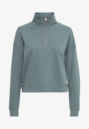 Lyseblå-grøn fleecepullover med høj krave og halvlynlås. Har en afslappet pasform, sænkede skuldre og ribbede manchetter.