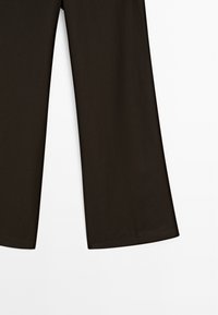 Černé široké kalhoty z měkké tkaniny, s čistým designem a rovnými sklady na nohavicích, bez viditelného kování nebo ozdob.