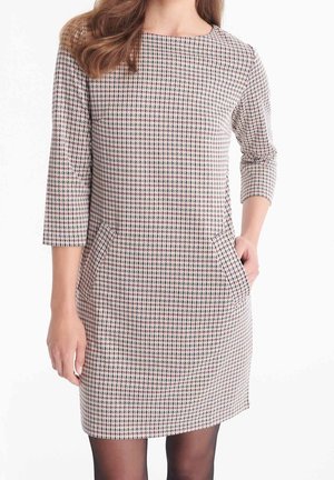 Räätälöity mekko, jossa on ruudullinen kuvio punaisin ja sinisin korostuksin. Mallissa on kolmanneksen pituiset hihat ja sivutaskut. Valmistettu teksturoidusta kankaasta.