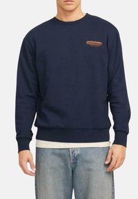 Sudadera marina hecha de una mezcla de algodón, con cuello redondeado, puños y dobladillo acanalados, y logotipo en texto naranja en el pecho.