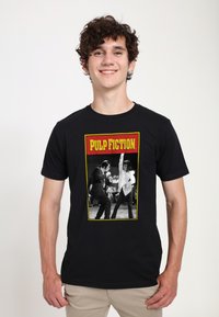 Černé bavlněné tričko s grafickým potiskem z "Pulp Fiction" v červené a žluté, znázorňující černobílou taneční scénu.