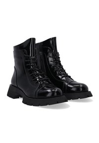 Stivaletti alla caviglia in vernice nera con lacci frontali, cerniera laterale, suola in gomma chunky e punta arrotondata.