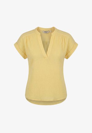 Blouse jaune à manches courtes avec col en V, col mandarin, poignets retroussés, épaules froncées et ourlet légèrement arrondi.