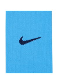 Tessuto lavorato a maglia di colore azzurro chiaro con il logo Swoosh di Nike in blu scuro. La texture è liscia e presenta un motivo uniforme.