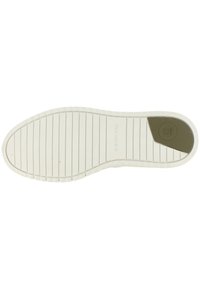 White rubber shoe sole with textured lines and a green accent near the heel, featuring a circular logo imprint.