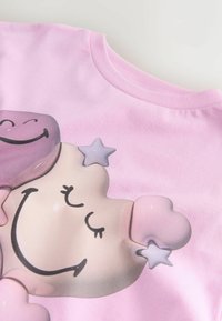 Růžové tričko s grafickým motivem usmívajících se postaviček marshmallow, srdíčky a malými hvězdami, měkká textura, design s kulatým výstřihem.