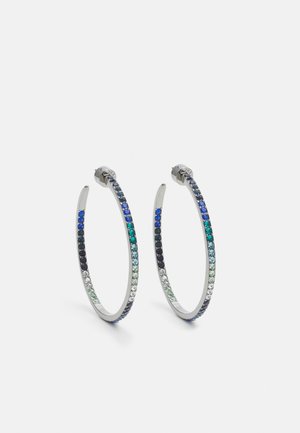 Paire de boucles d'oreilles créoles en argent ornées de petites pierres précieuses bleues, vertes et blanches sur fond blanc.