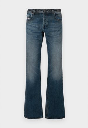 Calças de ganga azuis desbotadas com um design de perna flare, cinco bolsos e uma cintura escura. Apresentam desgaste suave nas coxas.