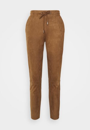 Brązowe zamszowe spodnie zwężane z regulowanym paskiem w talii oraz srebrnymi końcówkami sznurka, bez widocznych kieszeni, na białym tle.