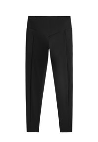 Leggings noirs avec une taille haute, présentant une texture lisse et des plis sur les côtés. Le design est ajusté le long des jambes.