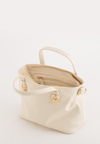Cream faux leather handbag with dual handles, gold hardware, zip closure, and an interior pocket. The bag has a soft texture and slouchy shape.