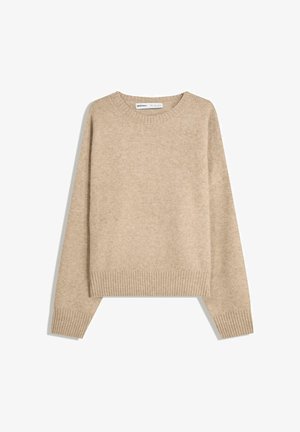 Beige tröja av mjukt, strukturerat stickat material. Har en rund halsringning, ribbade mudd och en kortad nederkant med sänkt axel.