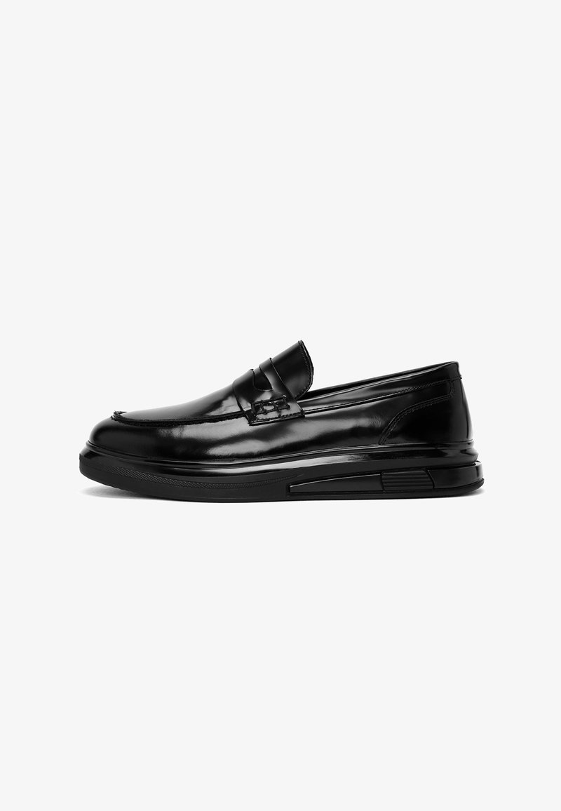 Black leather loafers with a sleek design, rounded toe, low heel, and rubber sole featuring textured accents on the side.