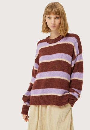 Jersey de punto con amplias rayas en marrón, lavanda y crema. Cuello redondo y ajuste holgado con mangas largas. Textura suave.