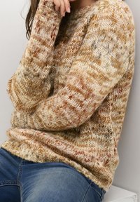 Pletený svetr v béžových a zemních tónech, s texturovaným vzorem a žebrovanými manžetami, s volnějším střihem a kulatým výstřihem.