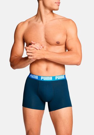 Navy blue boxer shorts with a soft texture and a light blue Puma logo waistband. The design features a fitted shape for comfort.