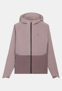 Lavandas viegls mētelis ar kapuci, priekšpusi aizpogājams ar rāvējslēdzēju un atstarojošiem elementiem. Izgatavots no gludas auduma ar tumšāku apakšējo daļu.