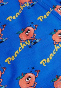 Sininen kangas, jossa on piirrosmainen oranssi hahmoita vihreiden lehtien kanssa, jotka käyttävät kenkiä, ympäröitynä kimalluksilla ja sanalla "Peachy" keltaisena.
