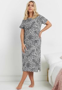 Svartvit leopardmönstrad nattklänning med korta ärmar, knälång nederkant, mjukt tyg, rund halsringning och sidofickor för lätt rörelse.