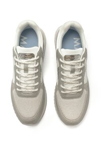 Zapatillas blancas y grises con materiales de malla y ante, que presentan un diseño texturizado, cordones planos y un detalle metálico de marca.