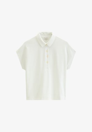 Λευκό πόλο με κοντά μανίκια, κλασικό γιακά και τέσσερα μπεζ κουμπιά στο μπροστινό μέρος, εμφανιζόμενο σε απλό φόντο.