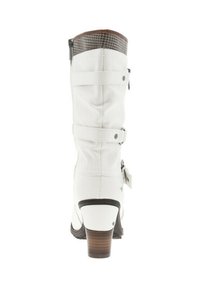 Botte blanche hauteur genou avec un accent marron texturé en haut, dotée de sangles décoratives et d'un talon modéré. Matériau synthétique lisse.