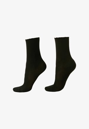 Svarta ribbade strumpor med medellång längd, med en slät textur och en sömlös tåt design. Inga synliga mönster eller detaljer.