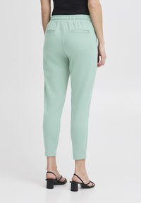 Ljus mintgrön joggerbyxor med stretchmidja, slim fit och två bakfickor. Matchas med svarta klacksandaler.