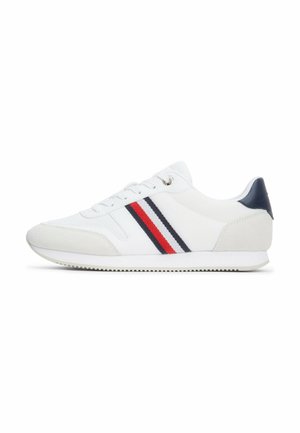 Sneakers bianchi con una parte superiore in tessuto testurizzato, dettagli in suede grigio e strisce diagonali in rosso e blu navy. Presentano una chiusura con lacci e una suola in gomma.