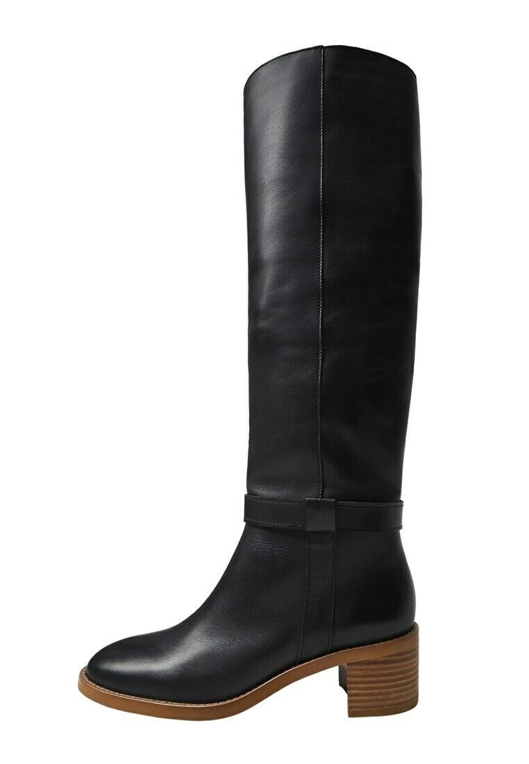 Bota de cuero negra hasta la rodilla con tacón cuadrado apilado marrón y correa decorativa alrededor del tobillo.