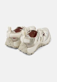 Χοντροπάπουτσα αθλητικά με μπεζ και εκρού υφασμάτινο επάνω μέρος, λαστιχένια σόλα, τονισμένη πίσω φτέρνα και ανάγλυφο μοτίβο πέλματος.