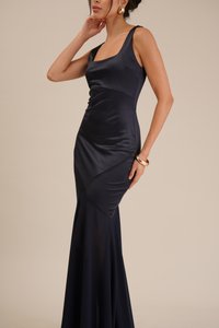 Navy satin evening gown with a fitted bodice, scoop neckline, and flared bottom. Features diagonal panel detailing and a smooth, soft texture.