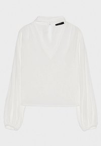 Vit blus med långa, något puffiga ärmar, V-ringning och knapphål baktill. Tillverkad av lätt, genomskinligt tyg för en flytande look.