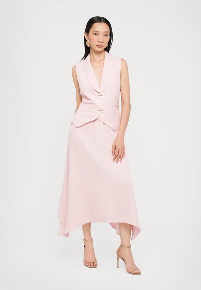 Abito senza maniche di un delicato rosa chiaro con scollatura a V profonda, corpino aderente e orlo asimmetrico. Presenta due bottoni metallici in vita.