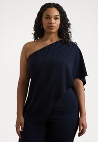 Tumši zils vienas pleca kleita, kas izgatavota no gludas auduma, ar drapēta dizainu un mīkstu tekstūru. Garā piedurkne plūst pāri rokai un sāniem.